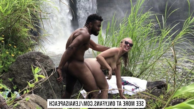 Блондинка сексуально трахается с негром в джунглях перед водопадом